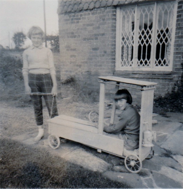 Heather and friend with their homemade trolly outside the farmhouse front door